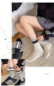 Detail of ribbed mid-calf socks featuring contrast stripes and small fabric tag labels