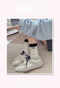 Close-up of polka dot crew socks with lettuce trim and retro sneakers on a textured rug