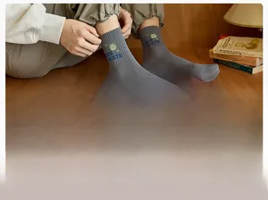 Close-up of gray cotton mid-calf socks with I LOVE SKATE text and cartoon smiley face