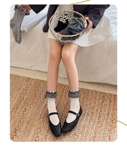 Detail of JK Lolita socks with ruffled lace and plaid patterns in a cozy home setting
