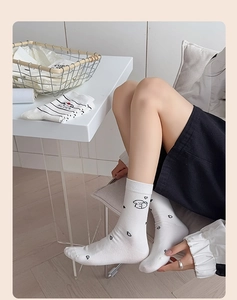 Detail of white cotton socks with cute cartoon dog patterns and sweet black heart prints
