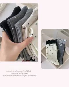Detailed close-up of polka dot socks with ruffled edges and stitched letter labels