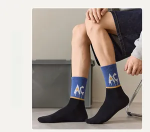 Detail view of blue and black athletic socks with AC logo and yellow star on a male model