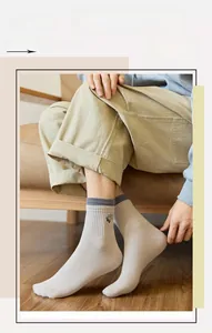 Detail of oatmeal crew socks with double ribbed cuffs and small cartoon embroidery