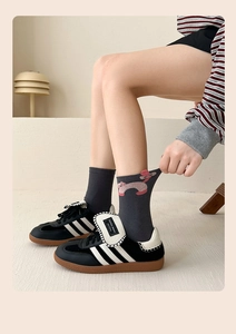 Close-up of dark grey cotton socks featuring a cute pink cat pattern and side details