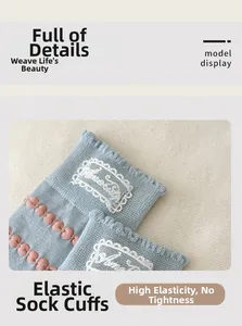 Close-up of light blue cotton sock featuring white lace trim and pink 3D polka dot texture