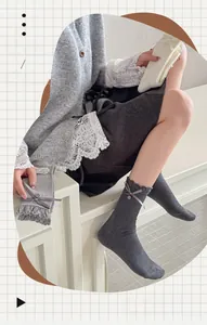 Close-up of knit crew socks with ruffled cuffs, ribbon bows, and button accents