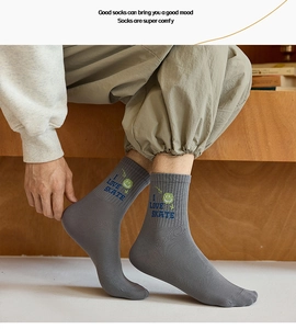 Close-up of grey cotton crew sock featuring I LOVE SKATE embroidery and green smiley face