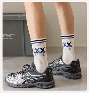 Detail of silver-grey sports shoes with breathable mesh and stylish graffiti crew socks