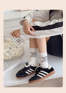 Close-up of white crew socks with cartoon puppy and black retro sneakers on casual scene