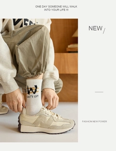Close-up of white breathable crew socks with WAT'S UP lettering and athletic shoes