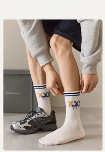 Detail of white mid-calf sports socks with blue stripes and yellow graffiti letters