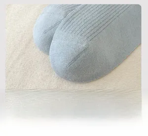 Detailed macro view of the seamless toe and smooth knit texture of light blue cotton socks