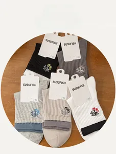 Detailed close-up of ribbed cotton crew socks with embroidery and brand packaging