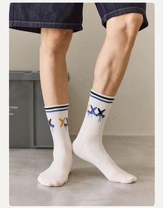Close-up of white crew socks with blue stripes and graffiti print on leg models
