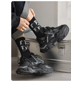 Close-up of black platform sneakers featuring mesh panels and FASHION lettering