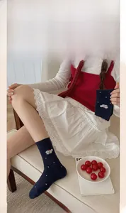 Chaussettes bleu marine à pois blancs et broderie chien portées par un mannequin