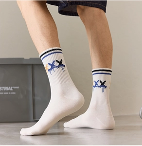Detail view of cotton crew socks with ribbed cuffs and graffiti X paint drop pattern