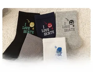 Detail of ribbed knit cotton mid-tube socks with embroidered smile icons and letters