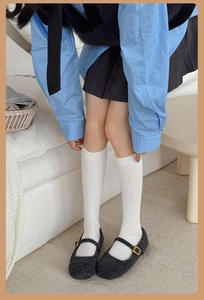 Detail of white ribbed cotton socks paired with black Mary Jane shoes for a collegiate style