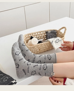 Detail of cute cat pattern socks with meow text and fabric label in assorted grey colors