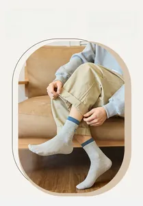 Detailed texture of gray cotton ribbed crew socks with blue cuffs shown on feet