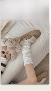 Gros plan de mules beiges à plateforme avec fausse fourrure et jambières en tricot