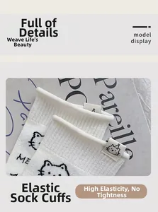 Detail of high-elastic ribbed cuff and cute cat patch on white knitted cotton socks