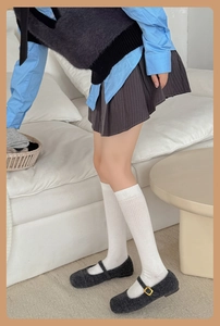 Detail of grey ribbed calf socks worn with Mary Jane shoes and a pleated skirt outfit