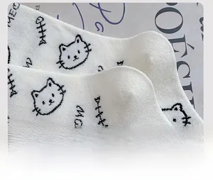 Close-up of white cotton knitted socks showing reinforced heel density and cat pattern