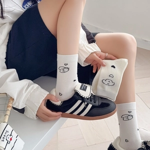 Cute white crew socks with cartoon puppy patterns shown on a model with sneakers