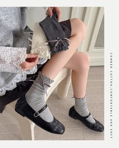 Detail of combed cotton mid-calf socks with ribbon bow, buttons and ruffled edges
