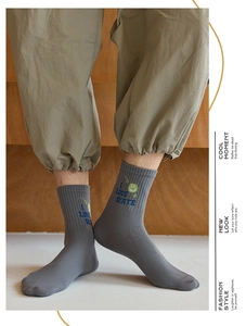 Detail of grey ribbed crew socks with I LOVE SKATE lettering and green smiley face icon