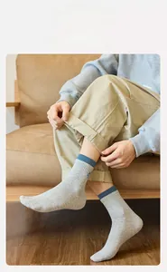 Detailed knit texture of gray men's crew socks with blue ribbed cuff and embroidery
