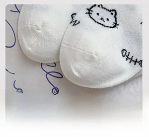 Macro shot of smooth toe seam and cartoon cat pattern on white knitted cotton socks