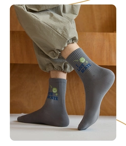 Detail of dark grey crew socks with green smiley face and 'I LOVE SKATE' text