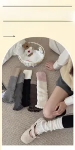 Gros plan sur des jambières tricotées bicolores avec texture côtelée et bord ondulé