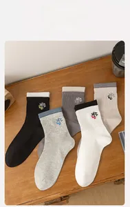 Flat lay of men's athletic crew socks with skateboard embroidery on a wooden table