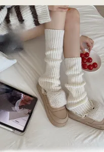 Gros plan de jambières en tricot blanc avec des chaussons en peluche beige doux