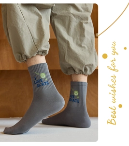 Close-up of gray cotton mid-calf socks with blue I LOVE SKATE text and green smile emoji