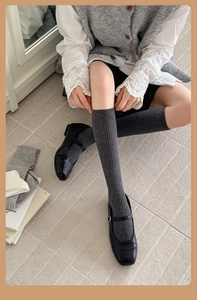 Detail of dark grey ribbed knit knee-high socks showing textured cotton material