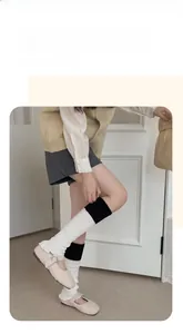 Vue détaillée des jambières en tricot noir et blanc avec des chaussures Mary Jane en peluche