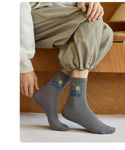 Detail of grey cotton socks featuring blue I LOVE SKATE text and green smiley face embroidery