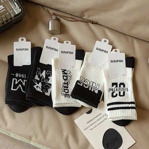 Five pairs of men's cotton crew socks with trendy letter prints in black and white colors