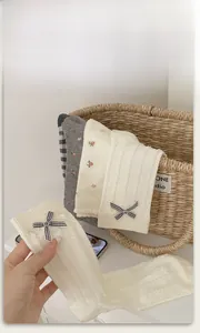 Close-up of knit cotton mid-tube socks with delicate plaid bows and floral patterns