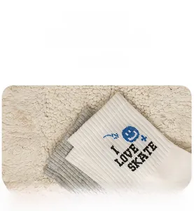 Detail of cotton crew socks with I LOVE SKATE text and blue smiley face embroidery