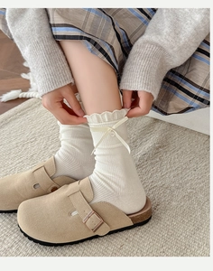 Detail of white ribbed crew socks with lace trim and sweet beige ribbon bows