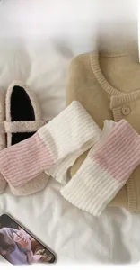 Gros plan sur des jambières en maille bicolore rose et blanc à texture côtelée