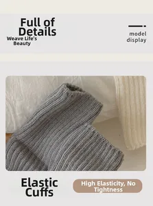 Vue détaillée des poignets élastiques sur des jambières en tricot gris et crème