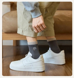 Close-up of men's dark grey ribbed socks with contrast trim and fine skateboard embroidery